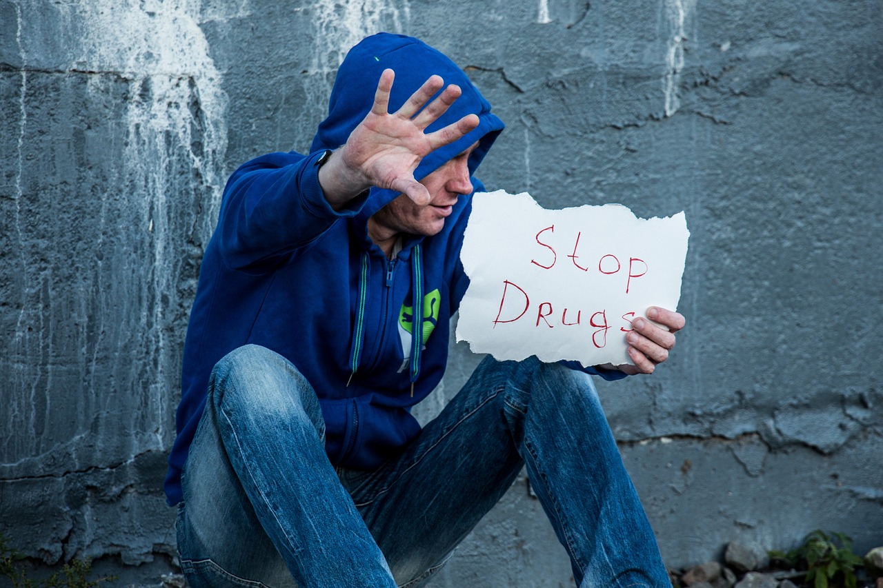 drug addiction - man holding sign saying stop drugs