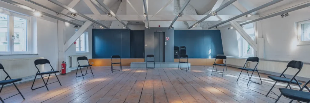 Stoelen in een cirkel in een lichte groepsruimte voor therapie of supportgroepen