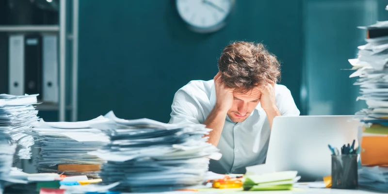 man sitting on desk stressed out